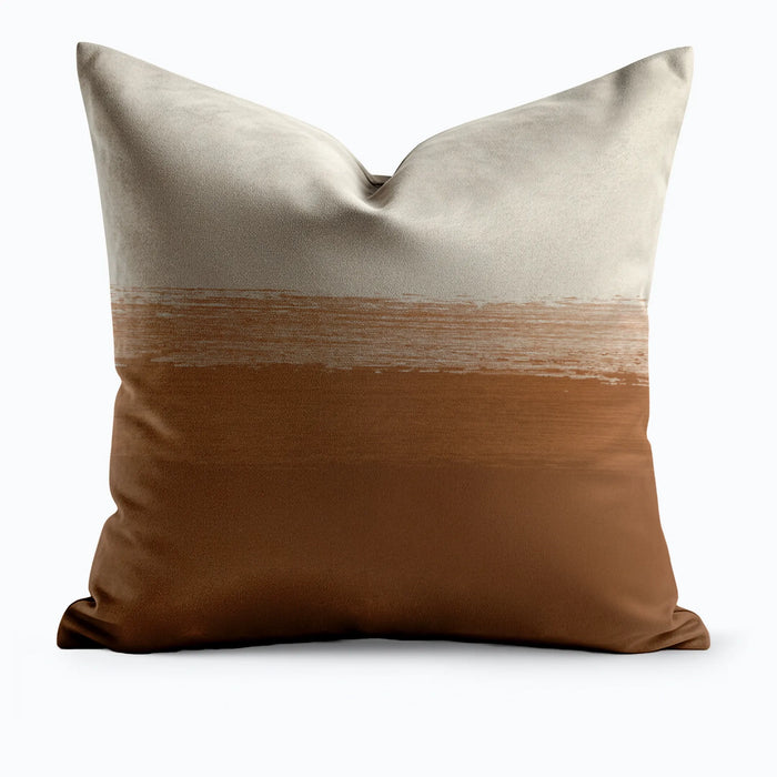 Desert Horizon throw pillow with wide cream top half and terracotta lower half divided by a painterly brushstroke