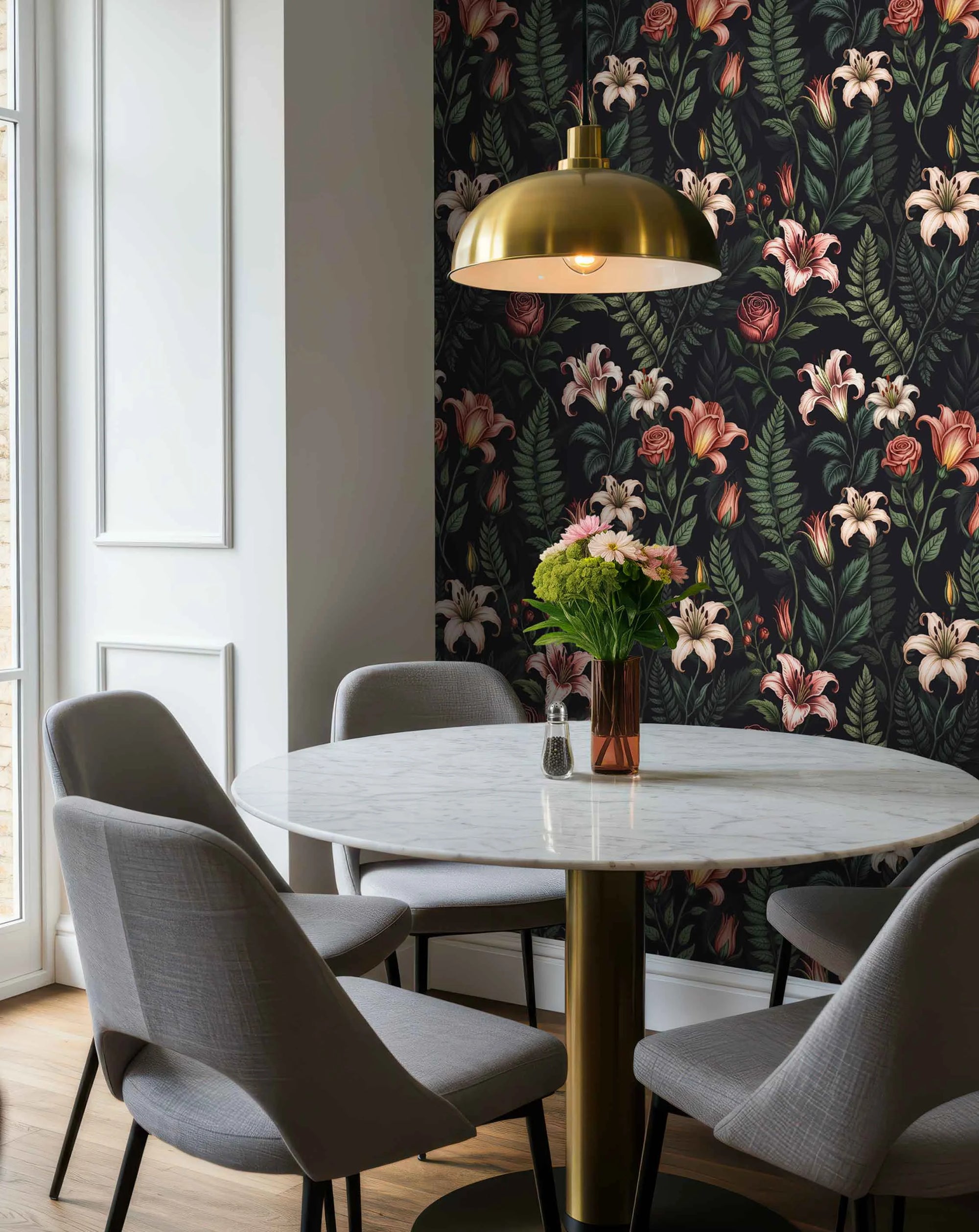 Dining room with a round light table, light gray chairs, and floral pattern wallpaper with pink lilies, roses, green leaves on a dark background