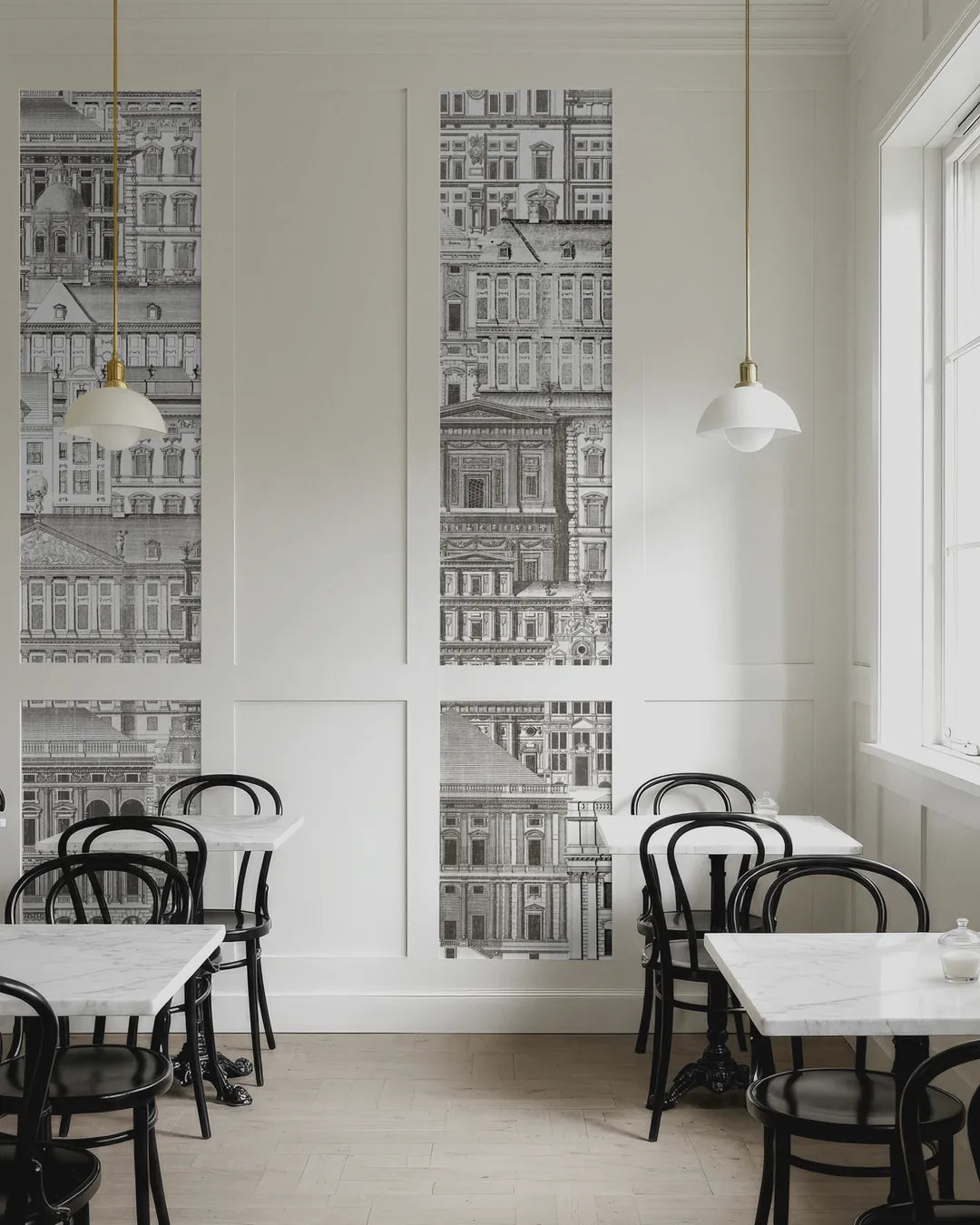Palazzo Grande wallpaper mural in tall wall panels above marble café tables and black bentwood chairs