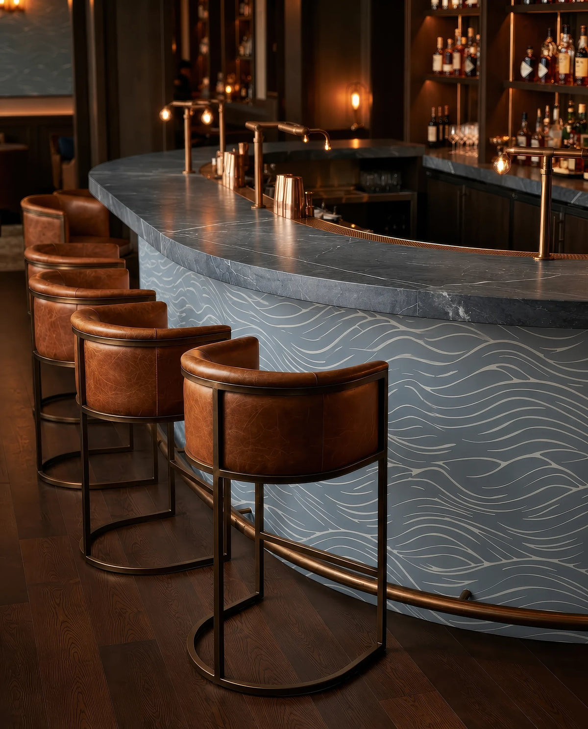 Quiet Current wallpaper wrapping a curved bar front with flowing wave motif, blue-grey tones, leather stools