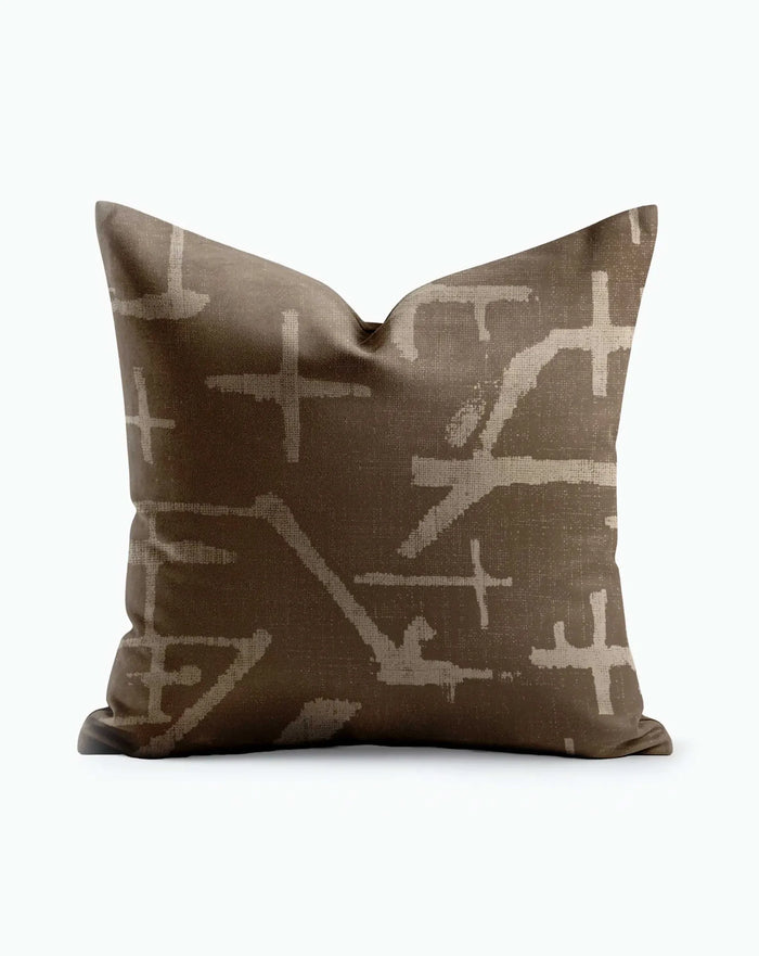 Savanna Mudcloth Throw Pillow with cream cross and brushstroke motifs on warm brown