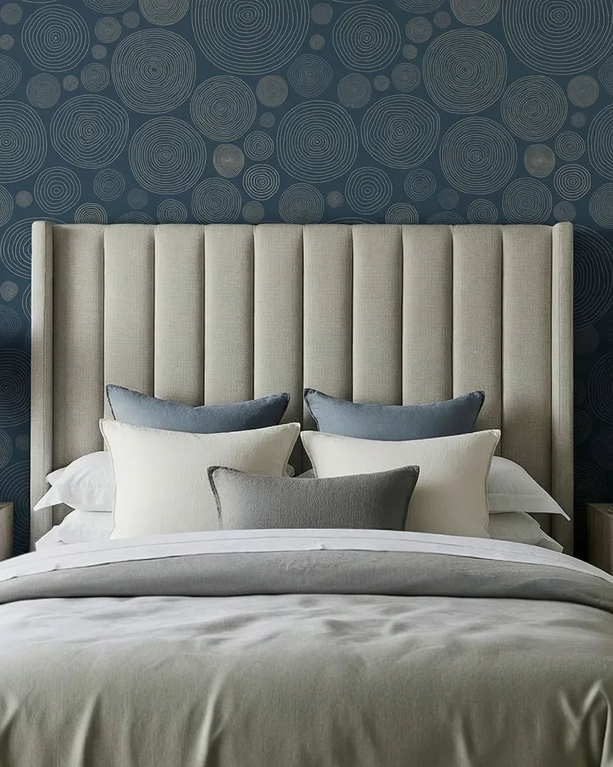 A bedroom after: circle-pattern wallpaper on the wall behind the headboard.